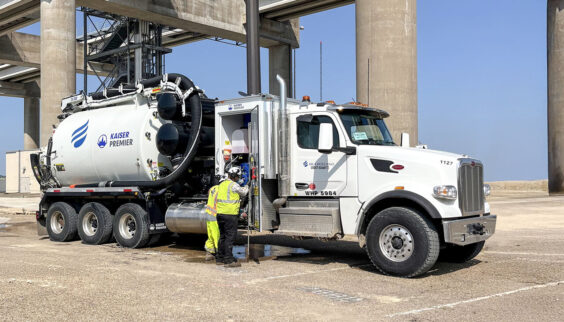 A man is standing next to a large truck.