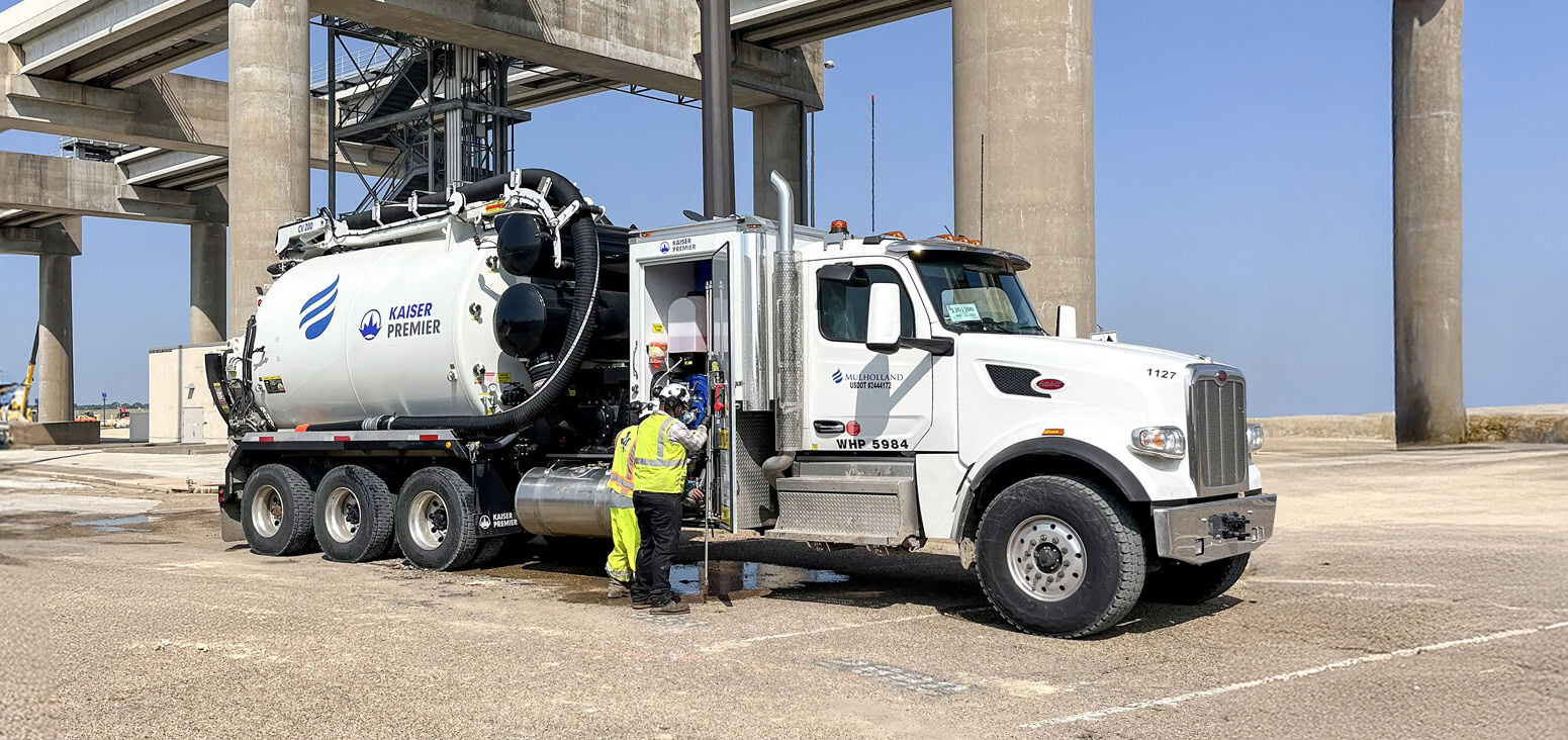 A man is standing next to a large truck.