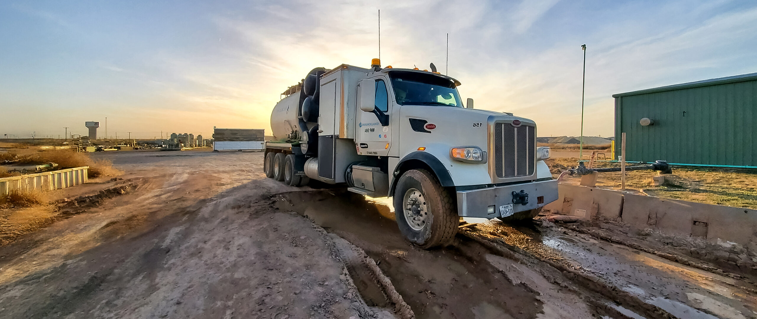 A large truck driving on a dirt road.