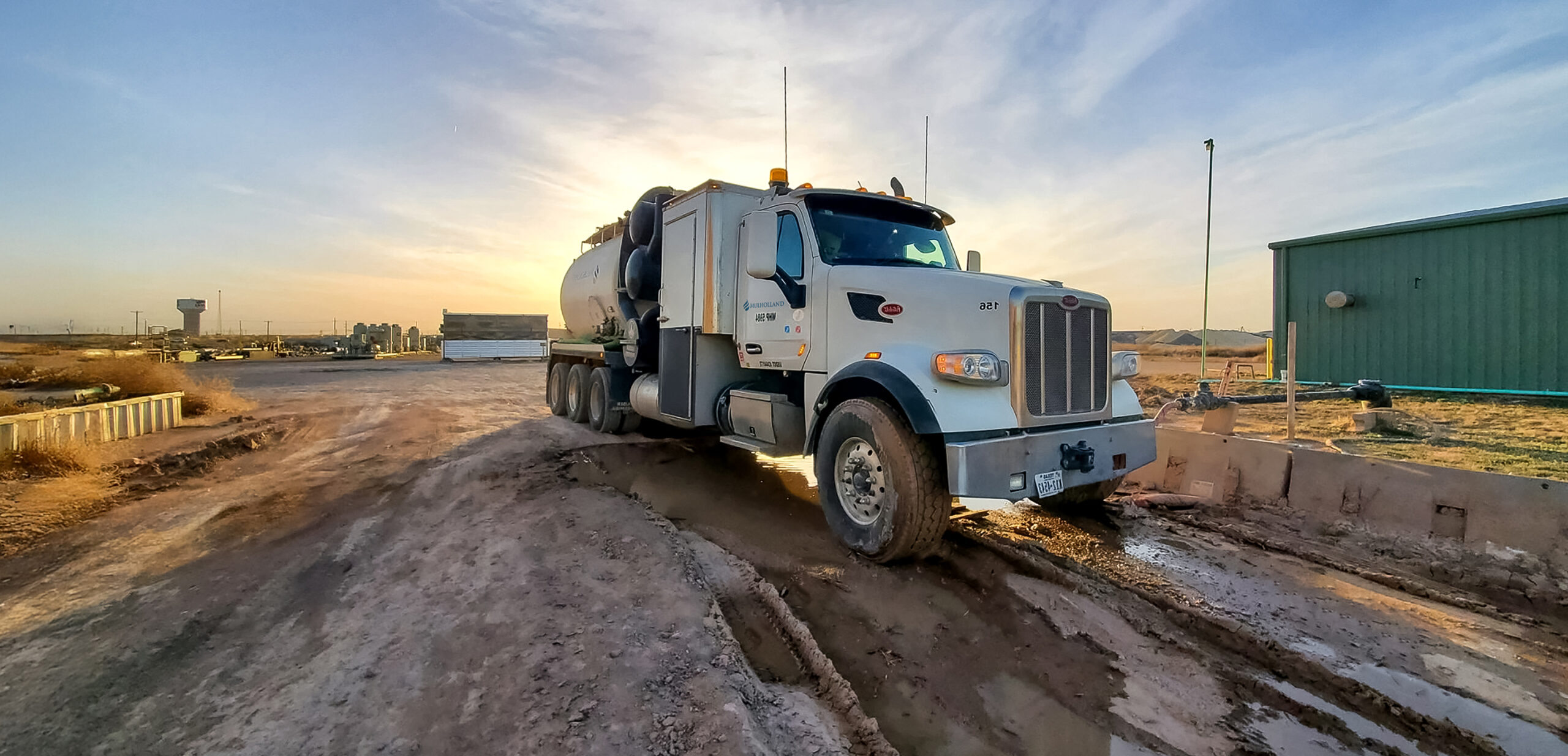 A large truck driving on a dirt road.