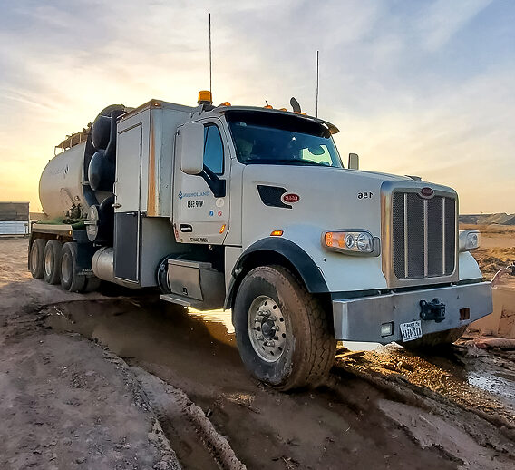 A large truck driving on a dirt road.